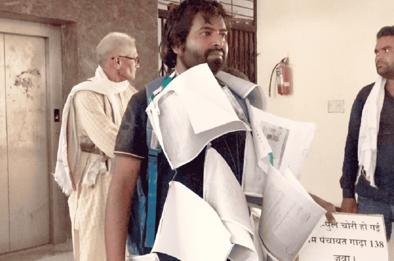सड़क के लिए अनोखा प्रदर्शन, रीवा में आवेदनों की माला पहनकर कलेक्ट्रेट में लेटा युवक