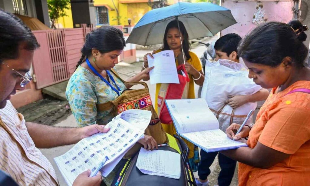 Election workers verifying voter list documents during Special Intensive Revision process in West Bengal