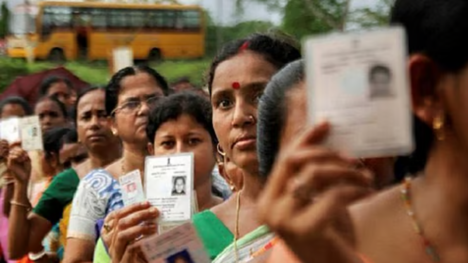 Voters stand in a queue holding identity cards during Arunachal Pradesh panchayat elections