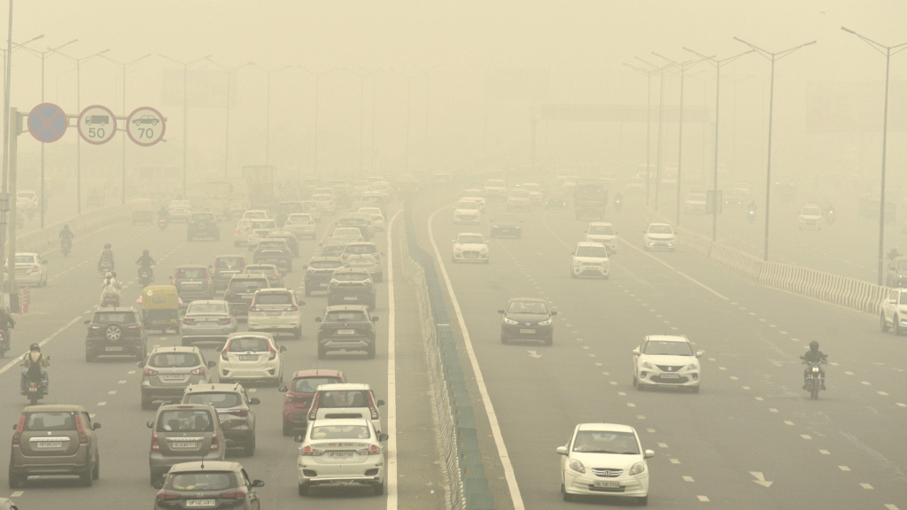 Heavy smog and traffic on a Delhi highway indicating severe air pollution and poor visibility