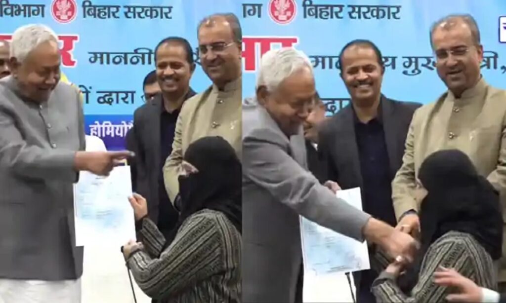 बिहार के मुख्यमंत्री नीतीश कुमार सार्वजनिक कार्यक्रम में मंच पर, आसपास लोग और मीडिया कैमरे मौजूद