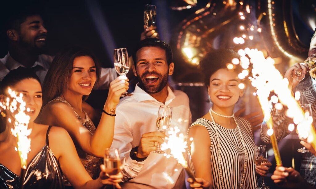 People celebrating New Year party with drinks and sparklers at a nightlife venue