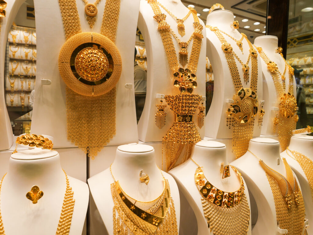 Close-up of gold bars, coins, and silver bricks showing record market high prices.