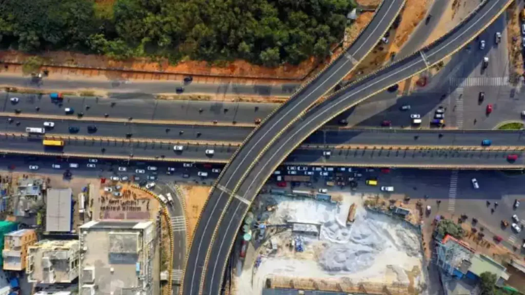 Aerial view of intersecting flyovers in Hyderabad with moderate traffic flow.