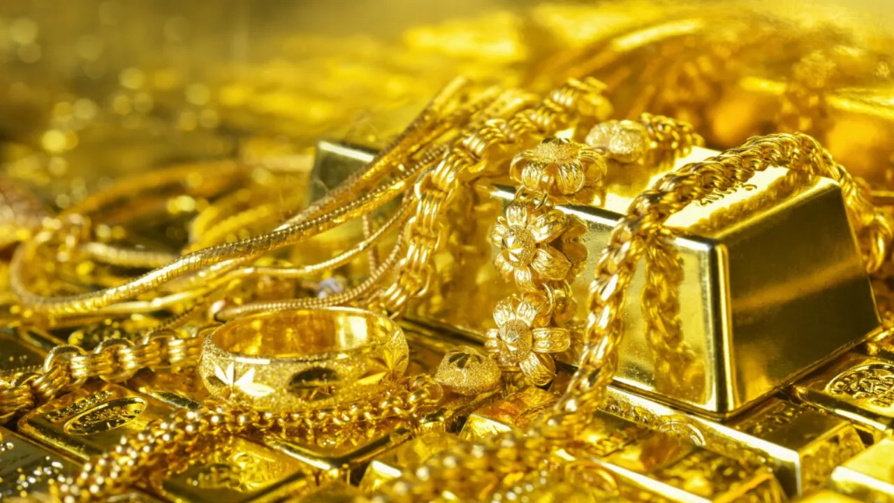 Close-up of gold bars and jewelry representing gold price today in India.