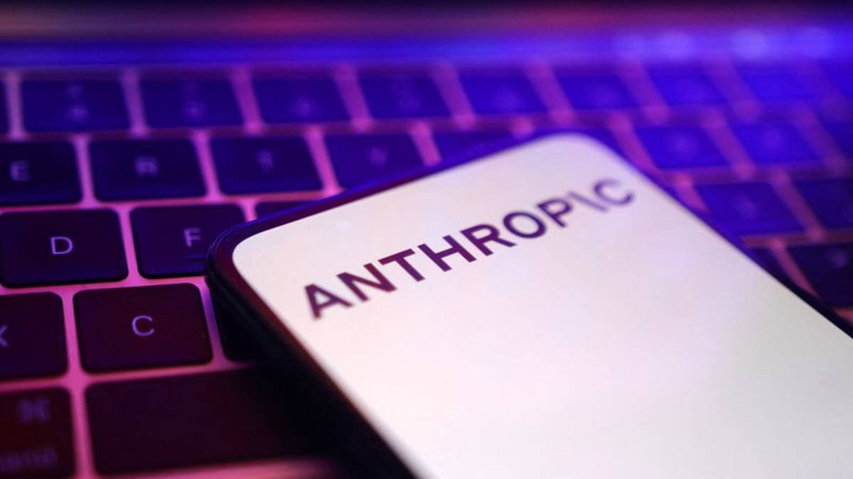 Close-up of a smartphone screen displaying the Anthropic logo against a backlit computer keyboard.