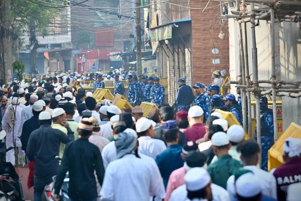 Muslim men showering rose petals on Delhi Police and RAF personnel in Uttam Nagar after Eid prayers.
