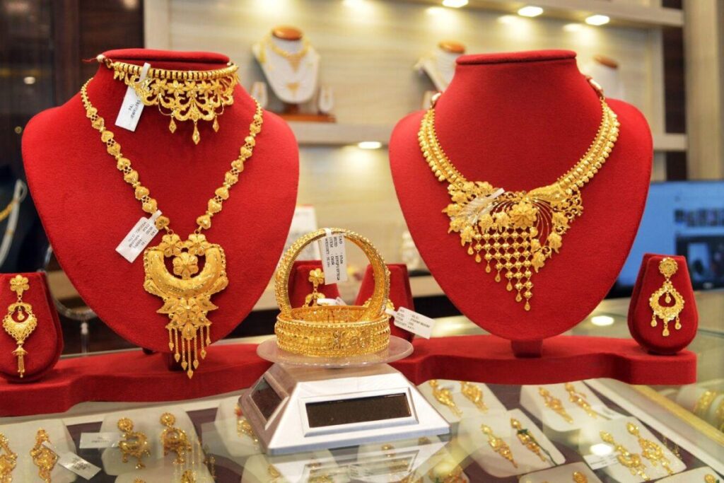 24-carat gold and silver coins with a downward trading chart reflecting the latest price drop in India.