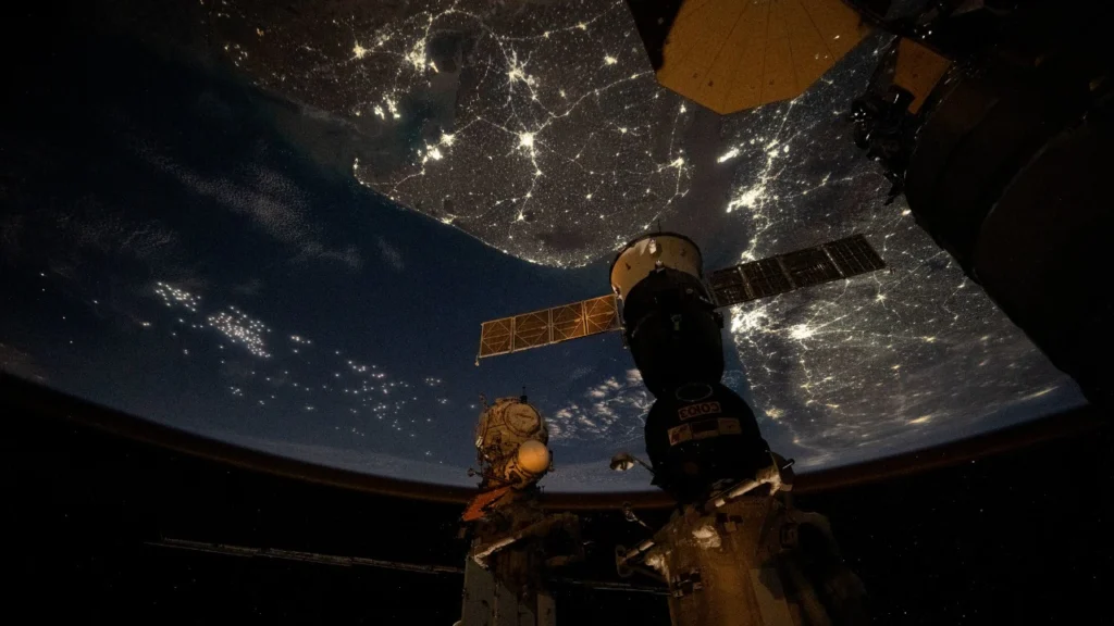 Nighttime view of India glowing from space, capturing bright city lights and the dark Himalayan border from the ISS.