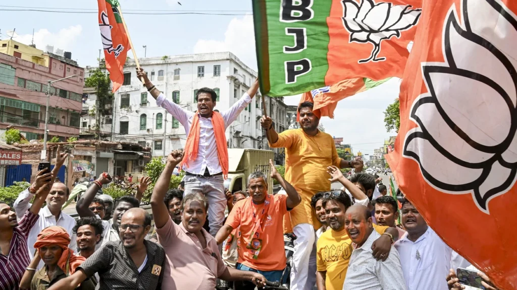 BJP workers celebrating with party flags in Kolkata following news of BJP lead in West Bengal election results.
