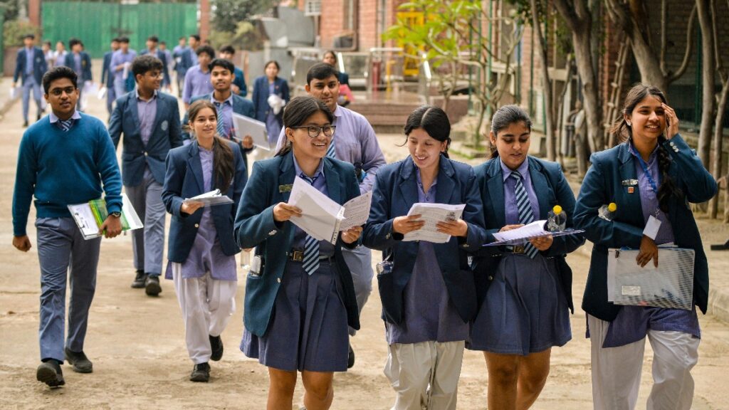 Students checking CBSE Class 12 Result 2026 on laptop and mobile devices.