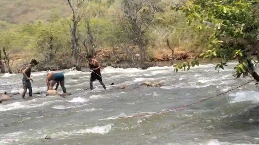 Young man trapped between the surging waves of Tons waterfall in Rewa